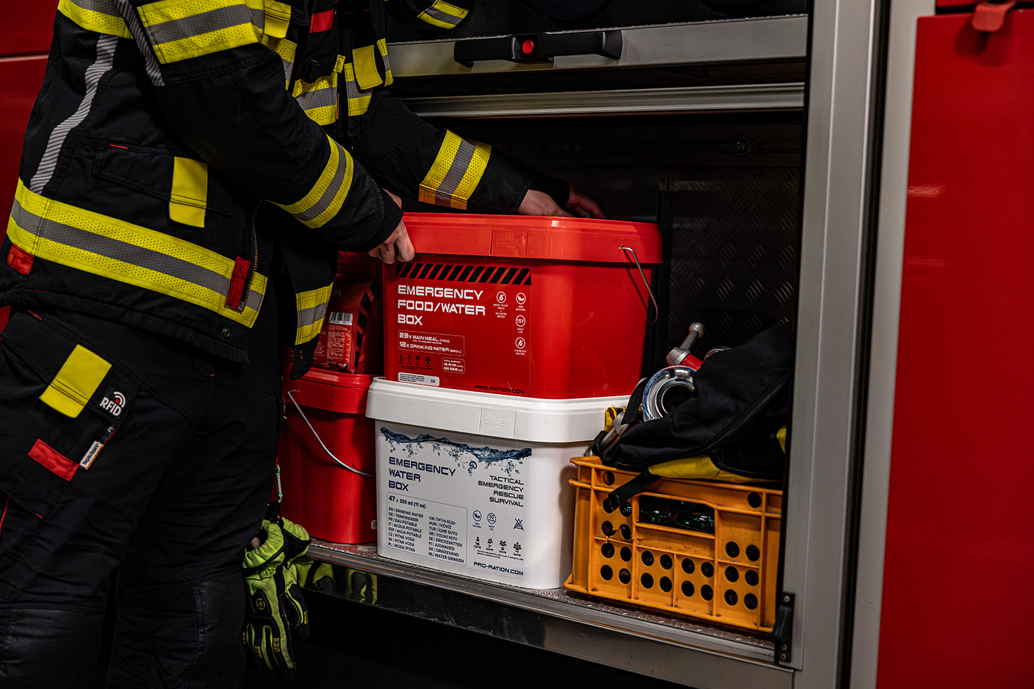 Hasiči ukládají Emergency Food/Water Box PRO-RATION do zásahového vozidla