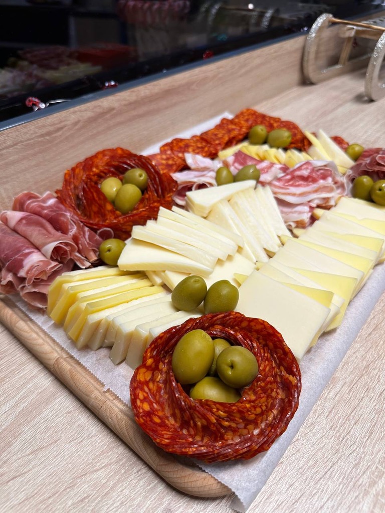 Chorvatské pohoštění: sýry, pršut, uzeniny a olivy na dřevěném prkénku
