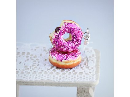 Růžovofialové donuty, jeden nakousnutý