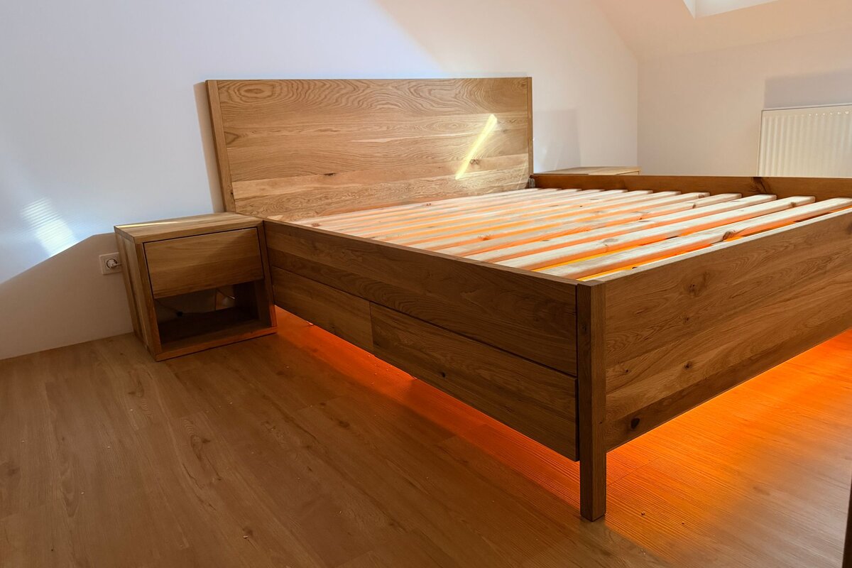 LED podsvícení pod dubovou postelí na míru s vestavěným nočním stolkem
