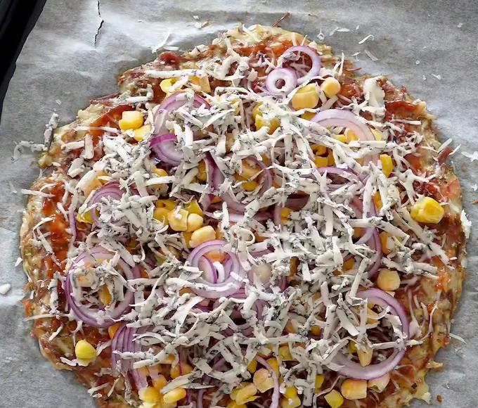 Pizza bez mouky s kukuřicí, cibulí a sýrem připravená k zapečení
