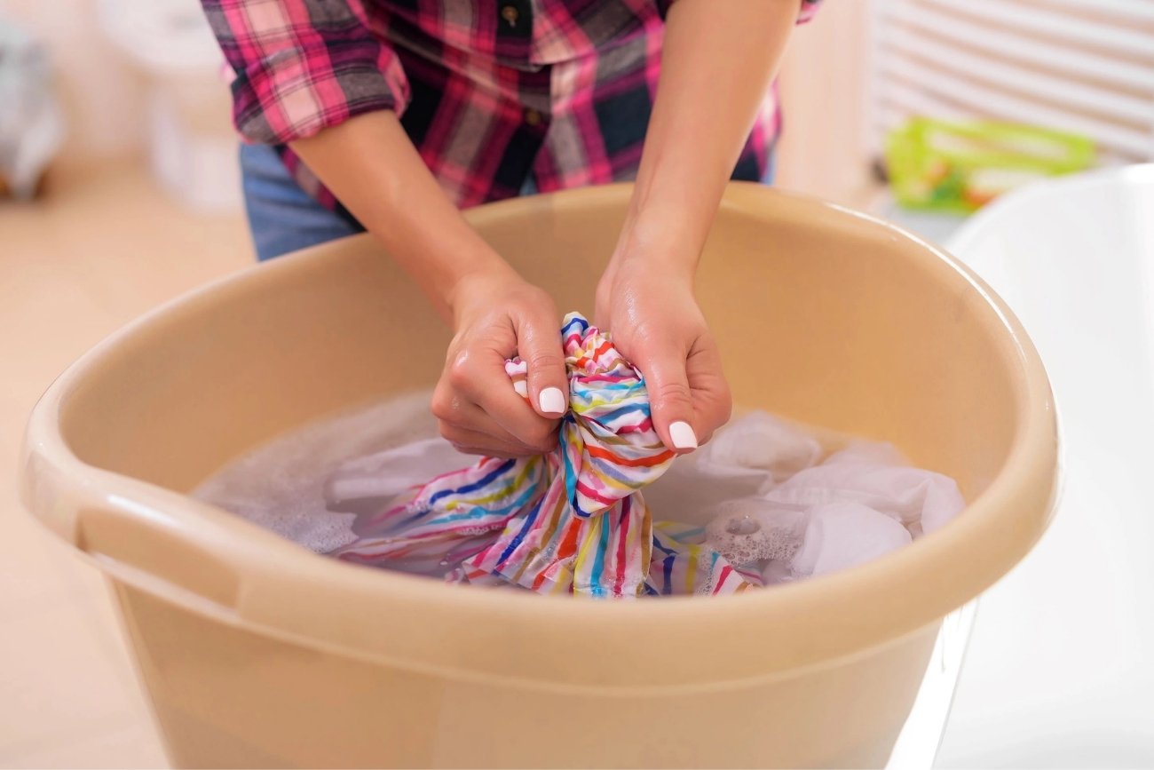 praní vícebarevného prádla v rukou