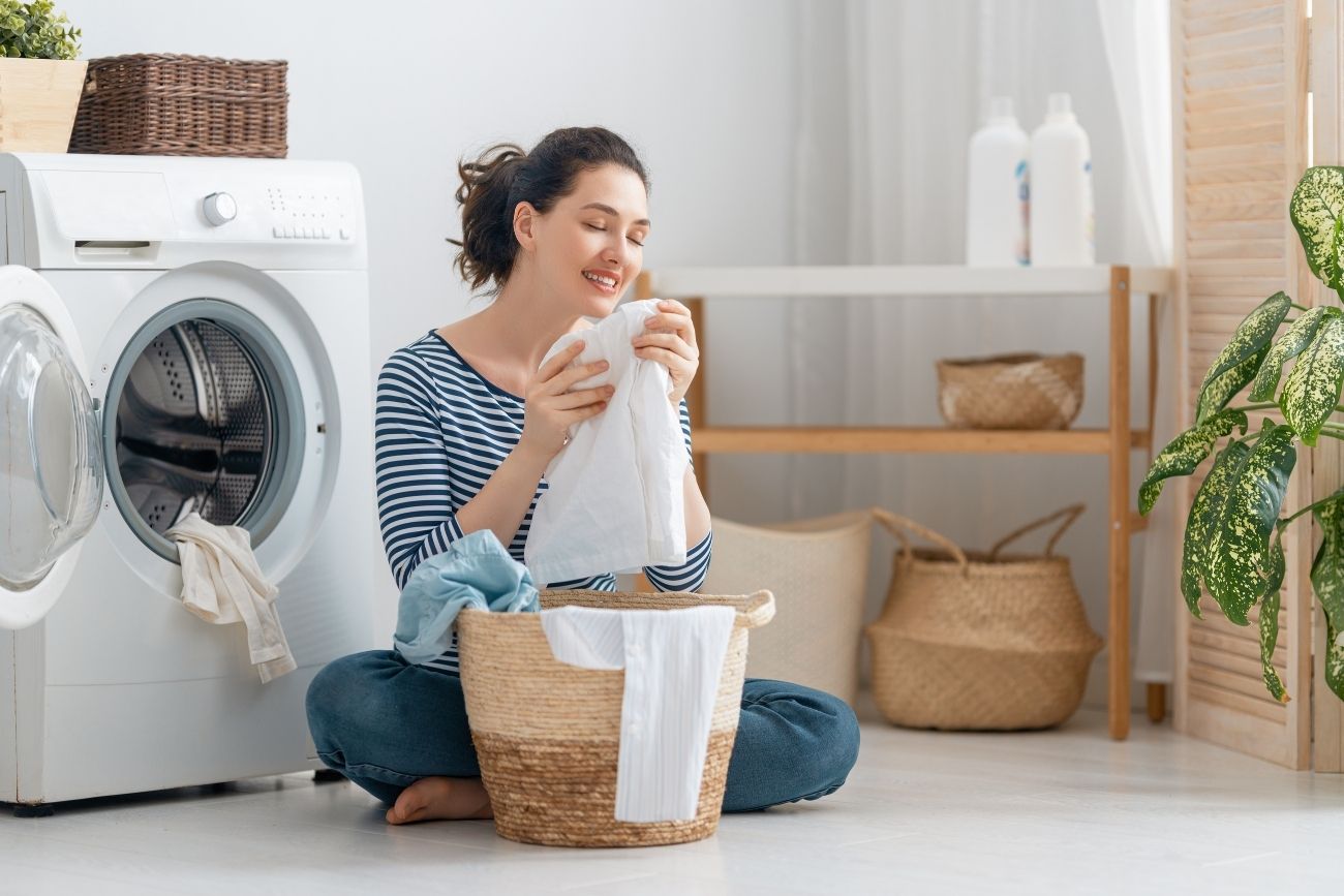 woman is holding white laundry