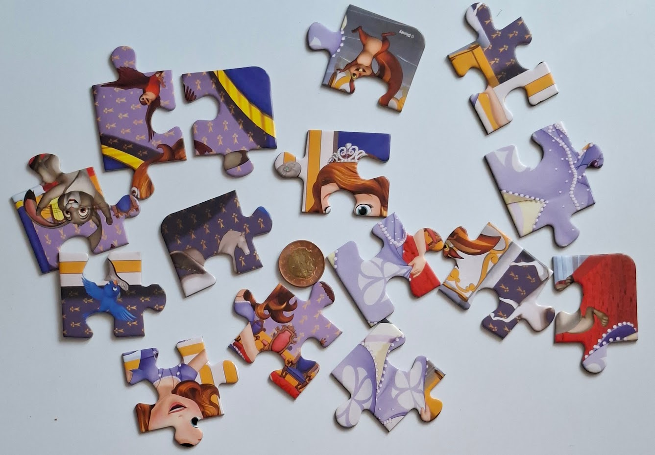 Porovnání velikosti dílků dětského deskového puzzle s padesátikorunou