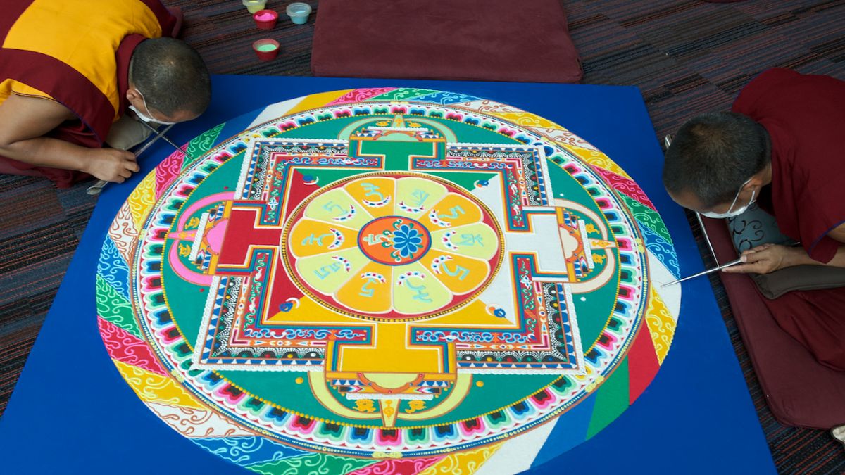 Tibetská písková mandala vytvářená z barevného písku