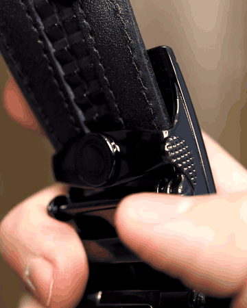 Detail automatické spony REDFIR, palec stiskne páčku a pásek se povolí