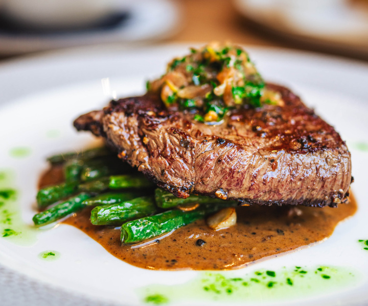 Stařený hovězí rib eye steak, krémová pepřová omáčka, fazolové lusky, gremoláta z rajčat a ančoviček, naše smažené hranolky