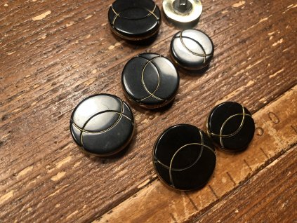 Černý kabátový knoflík se zlatým zdobením