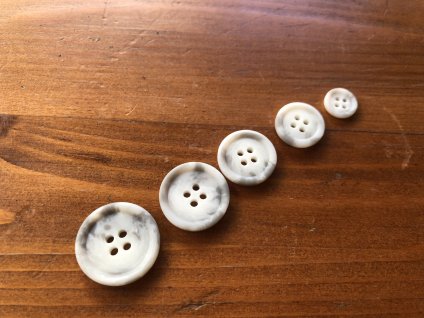 Světle šedý melírovaný knoflík