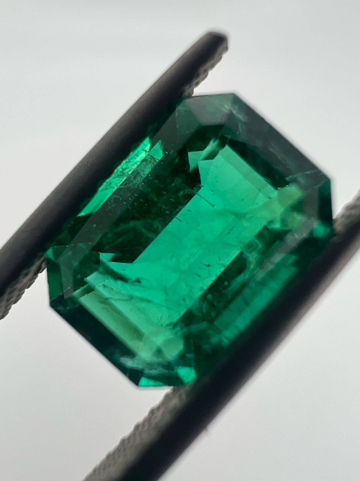 Přírodní smaragd s viditelnými vnitřními inkluzemi a typickou strukturou jardin.