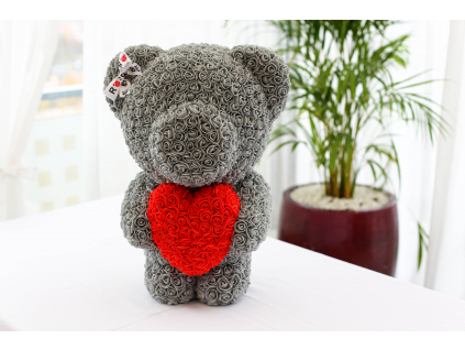 Šedý stojící medvídek z růží s červeným srdcem