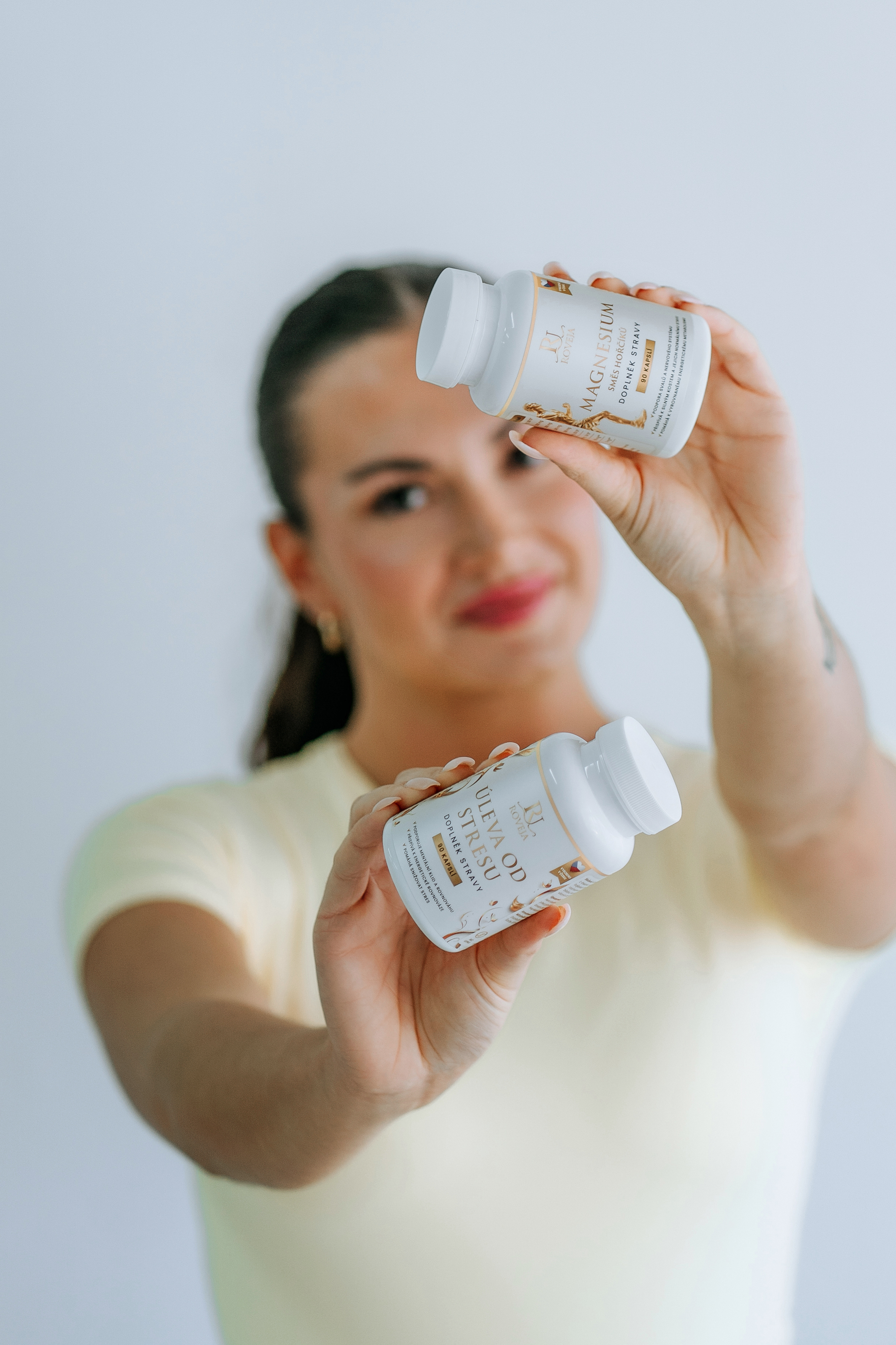 Žena drží české doplňky stravy Roveja Magnesium a Úleva od stresu