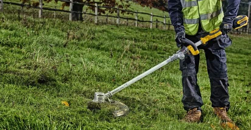 Aku strunová kosačka DeWALT DCMST561N pri práci na záhrade Detail aku strunovej kosačky DeWALT DCMST561N