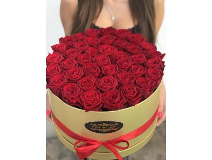 Zlatý box plný růží v náruči.