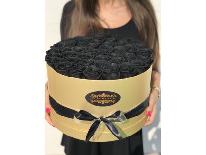 Květinový box plný černých růží v náruči.