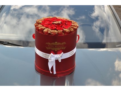 Luxusní červený box „Valentýnský Turbo Box“ s rudými růžemi a zlatými detaily, umístěný na lesklém povrchu auta.