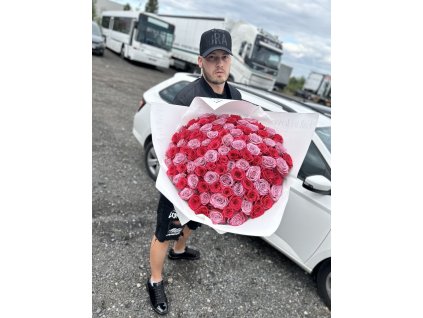 Puget 101 růží v jemných fialových a růžových odstínech, držený elegantním mužem před bílým autem na venkovním prostranství.