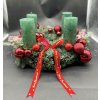 Detail adventního věnce s červenými ozdobami, zelenými svícemi a prémiovým chvojím.