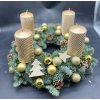 Detail zlatého adventního věnce s dekoracemi, hvězdami a prémiovým chvojím.