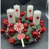 Detail červenobílého adventního věnce s hvězdami, cukrovými hůlkami a prémiovým chvojím.