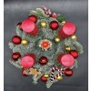 Pohled shora na vlajkový adventní věnec s Louskáčkem a červenými spirálovými svícemi.