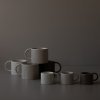 4 Keramické hrnky Mug Large 350 ml v kropenaté, šedé a černé barvě a 3 menší varianty hrnků Small 85 ml v kropenaté, černé a šedé barvě od značky DBKD - vyskládané na tmavém pozadí