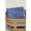 Ručník / osuška Mono v modré barvě od HAY v prádelním koši v nugátově barvě