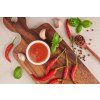 red hot chilli sauce tomato ketchup chilli sauce puree with chili pepper tomatoes garlic wooden cutting board stone surface top view