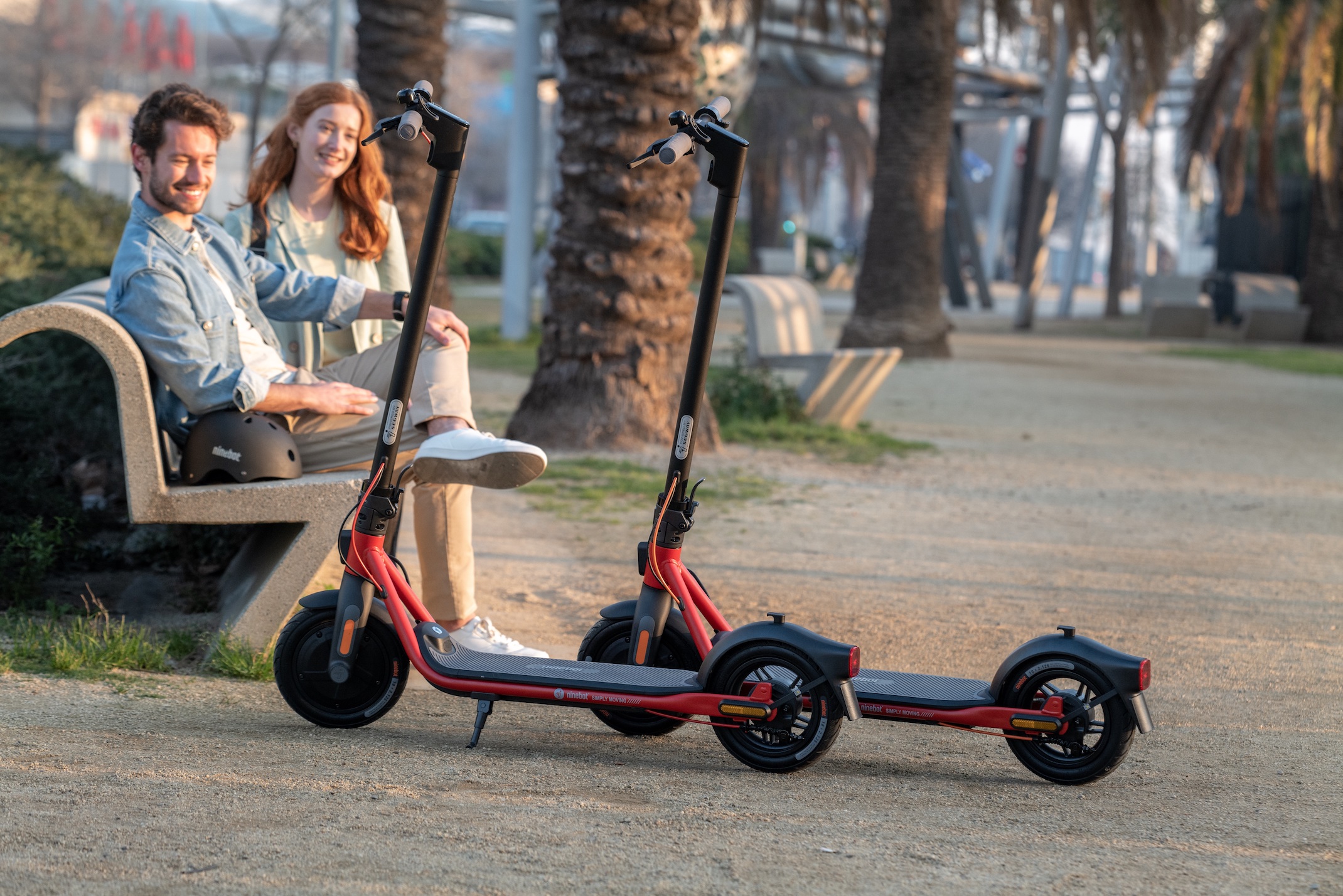 Ninebot KickScooter D series Powered by Segway_Lifestyle picture_ Man and woman sitting by parked kickscooters