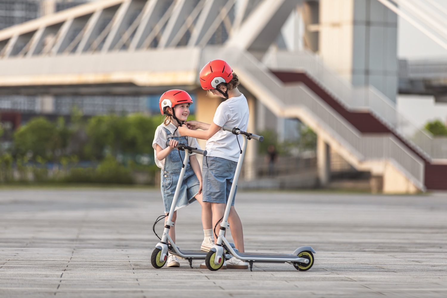 Ninebot KickScooter ZING C10 and C8_Lifestyle picture_Boy putting Segway helmet to girl_1