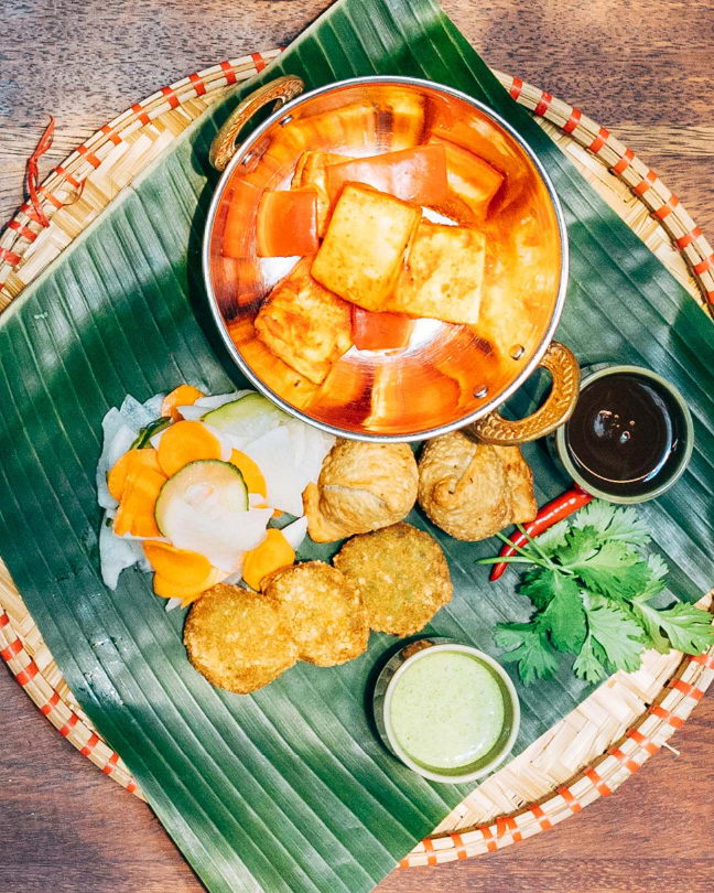 Indian variation of vegetarian starters - paneer cheese, samosa and pea tikki