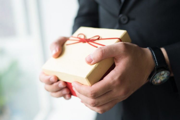 close-up-businessman-with-wristwatch-holding-gift-box_749x500