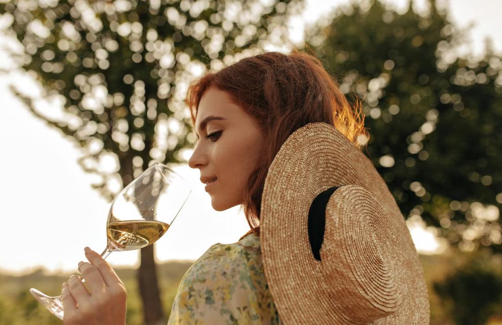 Žena degustujúca víno v prírode vo viniciach
