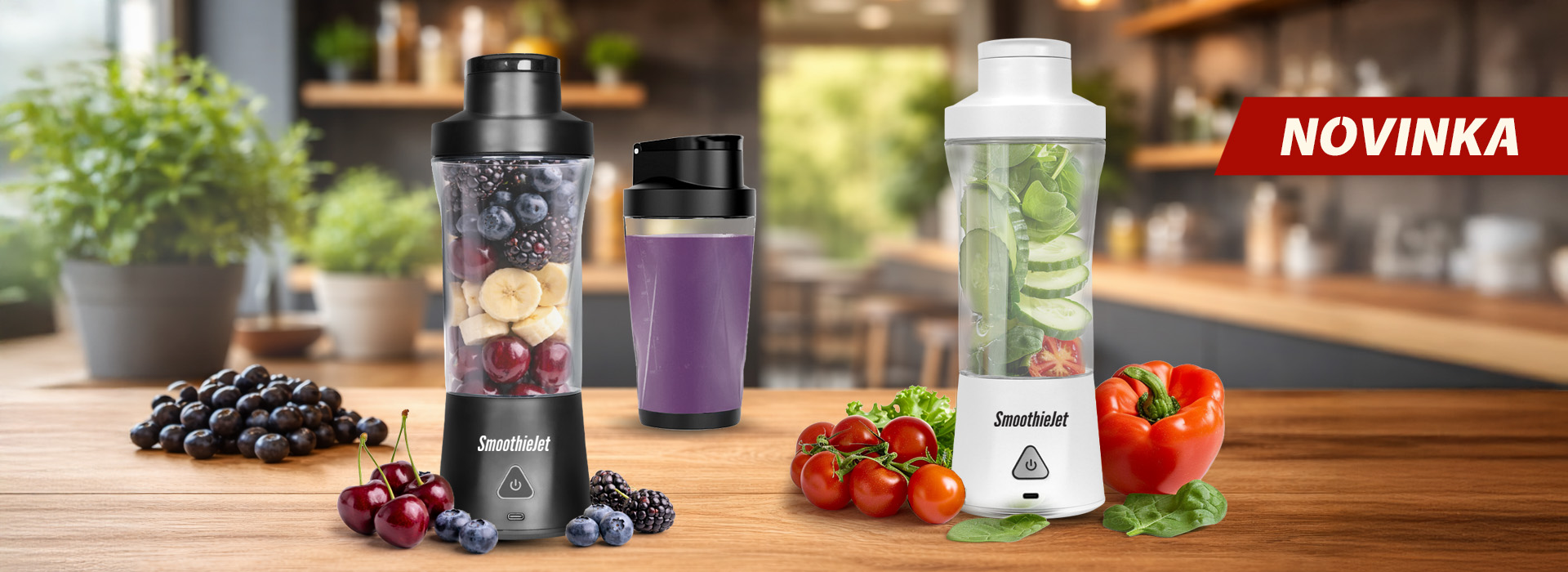Dva přenosné mixéry SmoothieJet v černé a bílé barvě na dřevěné kuchyňské lince, naplněné čerstvým ovocem jako borůvky, banány, kiwi a mango.