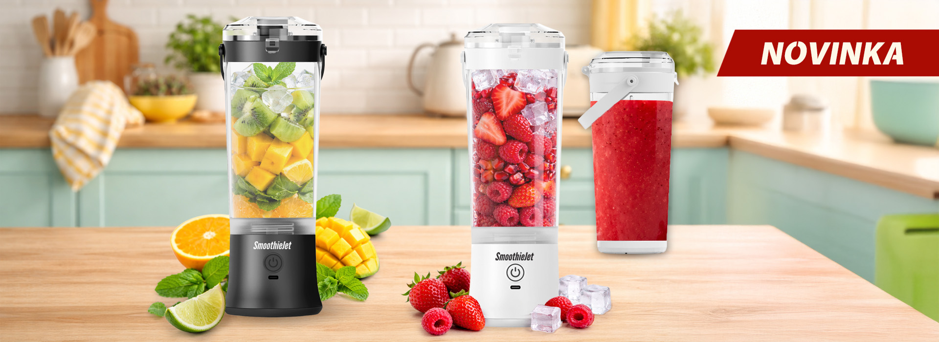 Černý a bílý přenosný mixér SmoothieJet s nápisem NOVINKA na kuchyňské lince, zobrazeno s čerstvým ovocem, jahodami a ledem.