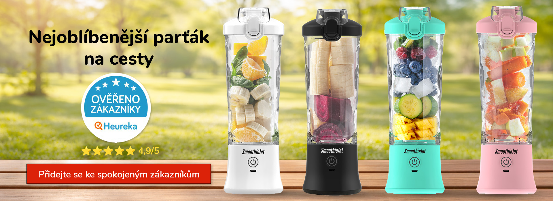 Čtyři přenosné mixéry SmoothieJet v různých barvách (bílá, černá, tyrkysová, růžová) naplněné čerstvým ovocem a zeleninou v exteriéru.