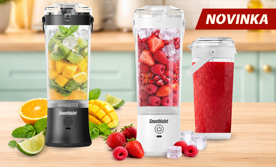Černý a bílý přenosný mixér SmoothieJet s nápisem NOVINKA na kuchyňské lince, zobrazeno s čerstvým ovocem, jahodami a ledem.