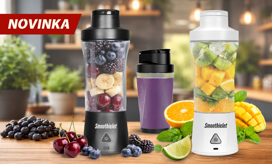 Dva prenosné mixéry SmoothieJet v čiernej a bielej farbe na drevenej kuchynskej linke, naplnené čerstvým ovocím ako čučoriedky, banány, kiwi a mango.