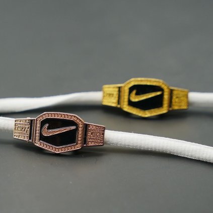 Close-up of pink motion-mark lace charm clipped onto laces — lightweight clip-on pendant; compatible with Nike Air Force 1, Dunk, Air Jordan and Air Max low-tops.