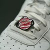 Pink enamel shoelace charm on laces — Art Series detail mounted through eyelets; fits Nike Air Force 1, Dunk and Air Max low-tops (flat laces).