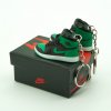 Close-up side profile of AJ1 “Pine Green” mini sneaker keychain with green overlays