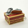 Close-up side profile of Vans Old Skool mini sneaker keychain showing iconic side stripe