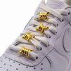 Gold barbed-wire shoelace clips threaded onto white flat laces