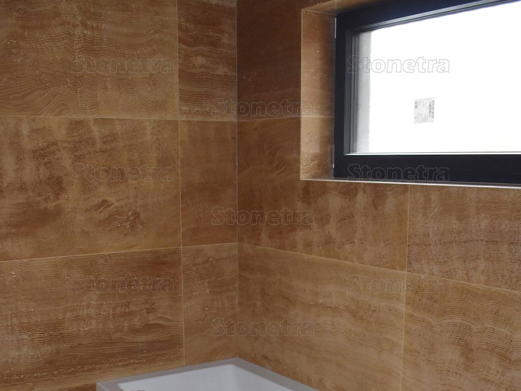 Bathroom corner with seamless wall and floor in Travertine Eldorado VC large-format tiles, filled and honed.
