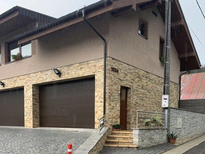 Stone wall cladding Gneis Rusty on modern house facade with warm rusty brown tones and natural texture.