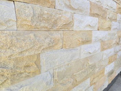 Split-face stone Sandstone Mensis in beige and cream shades displayed on an exterior wall with visible rough texture and layered blocks.