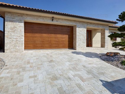 Driveway pavers in Travertine Classic leading to a garage, small-format 30×15 pattern.