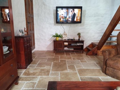 Floor tiles for living room in Travertine Noche French pattern, shown across a rustic lounge with TV and staircase.