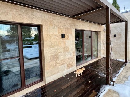 Natural stone tiles Travertine Classic highlight the texture of travertine on an exterior wall.