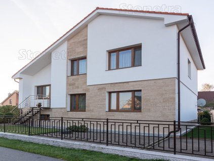Stone wall tiles Travertine Classic VC decorate a modern house façade with elegant beige travertine cladding.